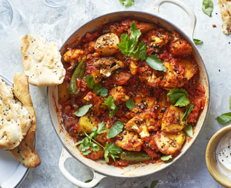 Aloo gobi curry with cauliflower and potatoes in a pot with bread